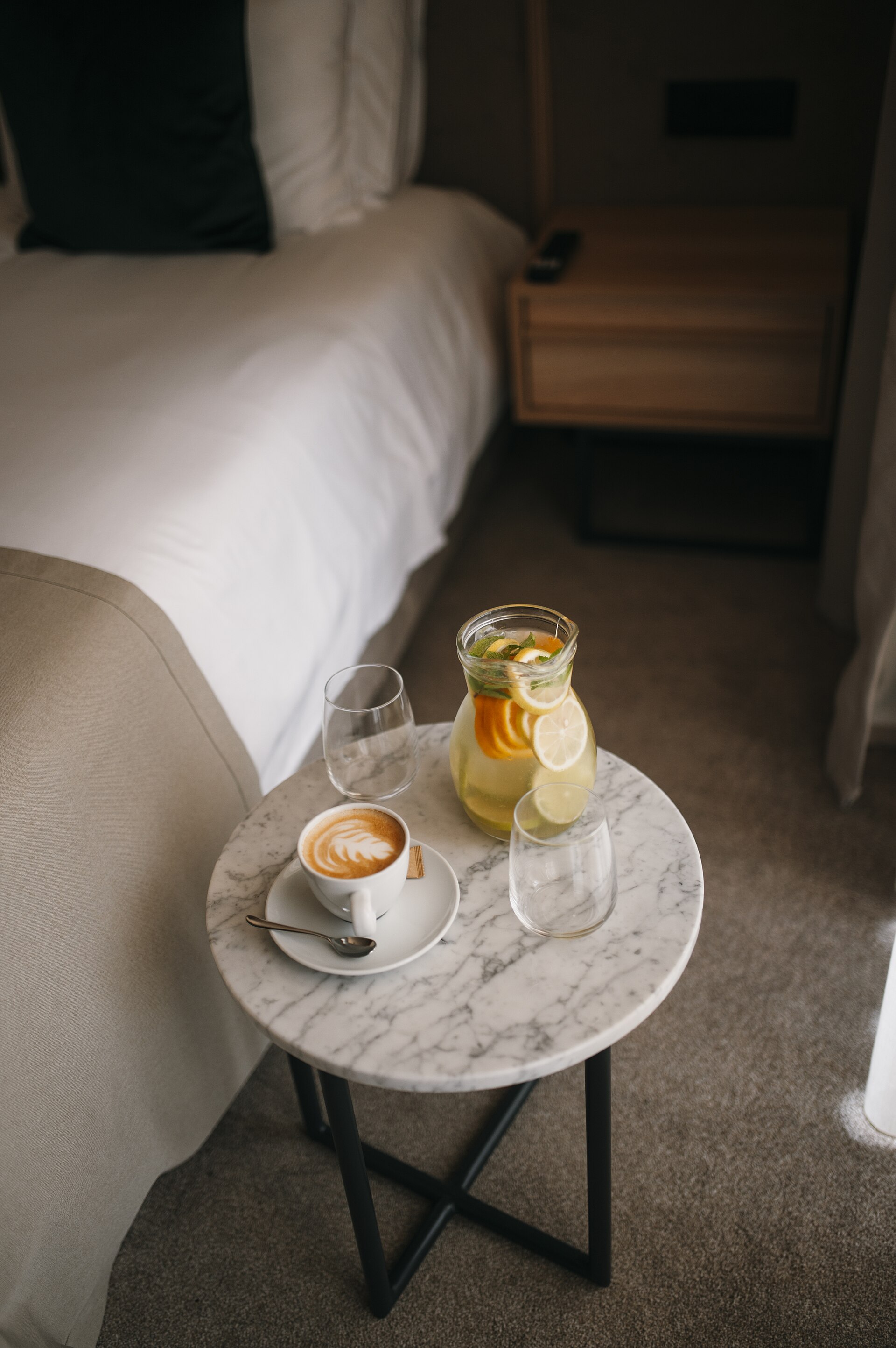 Coffee and water set out beside a guest bed